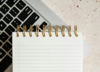How to Use AI for Blog Writing Without Violating Google’s Spam Policy Notepad on a laptop for AI-assisted content writing